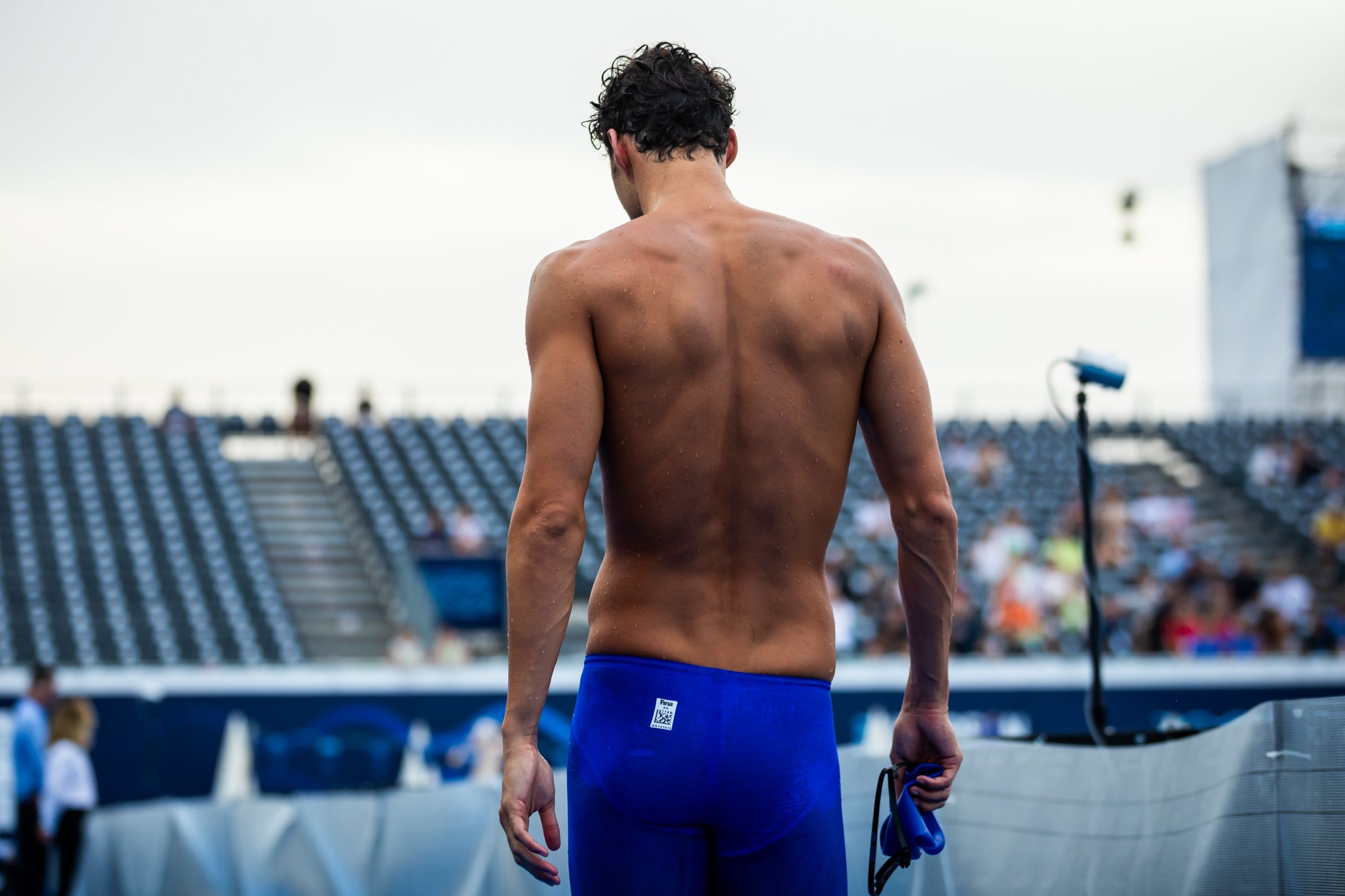 Vaggelis Makrygiannis walking to the blocks, goggles in hand
